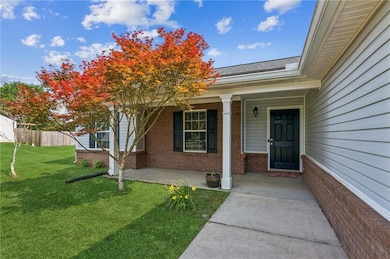 Doorway to property featuring brick siding, covered porch, and roof with shingles