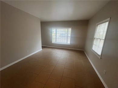 Unfurnished room with tile patterned floors and baseboards