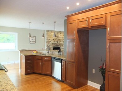 Kitchen has new cabinets and wood flooring.