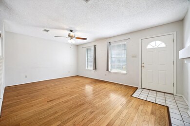 Entryway with a textured ceiling, light wood-type flooring, and a ceiling fan