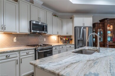 Open concept kitchen boasts many upgrages including the granite, arobesque backsplash and cabinets