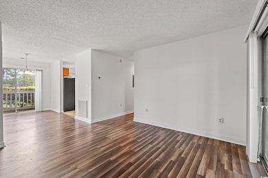Unfurnished living room featuring dark wood-type f