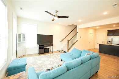 Living room featuring stairway, visible vents, lig