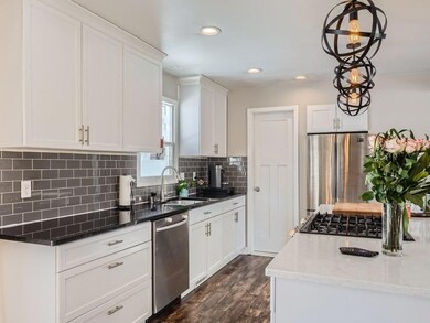 Updated Kitchen.  Subway tile backsplash, stainless appliances, pantry closet, center island and stylish light fixtures.   Kitchen window overlooks the fenced backyard.