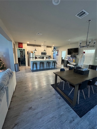 Dining room with a chandelier and dark wood-style floors