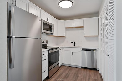 Kitchen featuring white cabinets, stainless steel