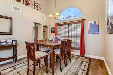 Dining space with a chandelier, baseboards, light