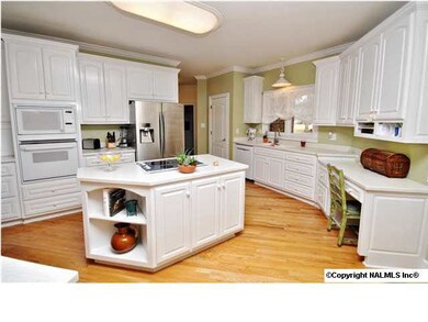 Loads of cabinets for organzation in this cooks kitchen! Solid service counter tops, Stove is down draft, great bar area.