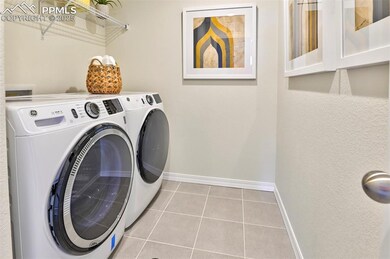 Laundry area with baseboards, independent washer and dryer, and tile patterned floors
