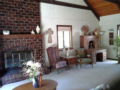 Family room enjoys a brick fireplace with raised h