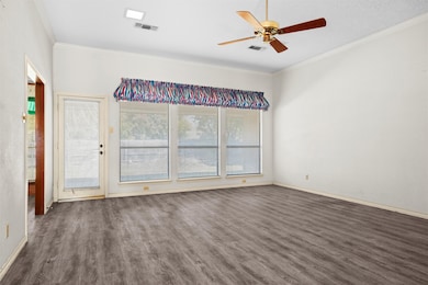 The living room features a wall of windows and a french door leading to the covered back patio.