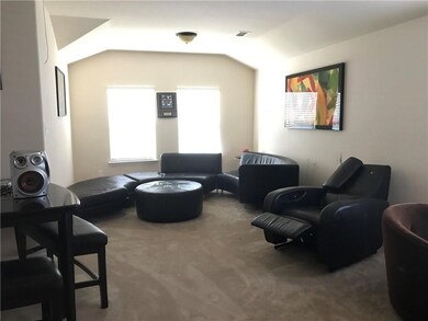 Living area featuring carpet and vaulted ceiling