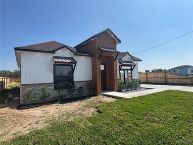 Rear view of property with a shingled roof and brick siding