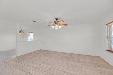 Empty room featuring ceiling fan, plenty of natur