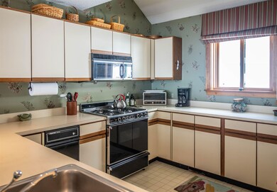 Large kitchen offers views of Okemo State Forest.