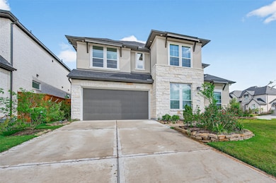 This is a modern two-story home featuring a stone and stucco exterior, a two-car garage, and a well-maintained front yard with landscaped garden beds. It offers a spacious driveway and a clean, inviting appearance.
