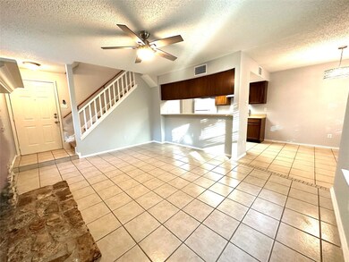 Unfurnished living room with light tile patterned floors, a textured ceiling, stairway, a ceiling fan, and a chandelier
