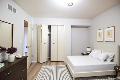 Bedroom with light wood finished floors and a closet