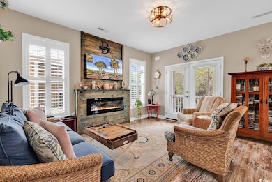 Living area with a stone fireplace, visible vents,