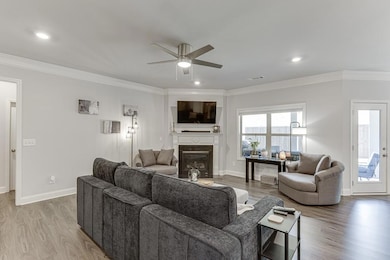 Living room with a ceiling fan, wood finished floo