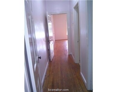 Hallway featuring wood finished floors and baseboa
