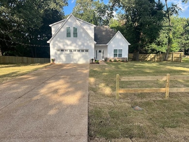 View of front of property with concrete driveway, a garage, and roof with shingles