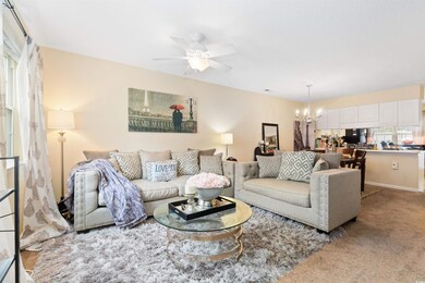 Carpeted living room with ceiling fan with notable