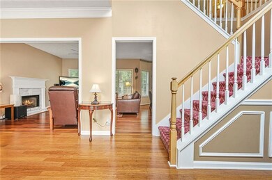 Staircase with wood finished floors, a high end fireplace, crown molding, and baseboards