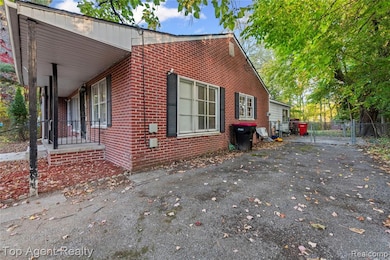 View of side of property featuring brick siding and a gate