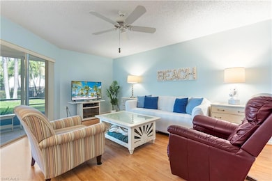 Living area featuring ceiling fan, a textured ceiling, and light wood-style floors