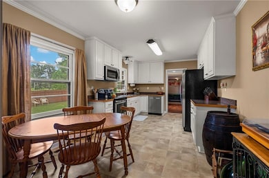 Kitchen with white cabinets, crwon molding, and stainless  steel appliances
