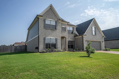 French country home featuring a garage, driveway, and brick siding