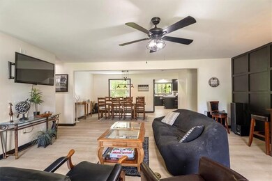 Living room featuring a ceiling fan, light wood-type flooring, and baseboards