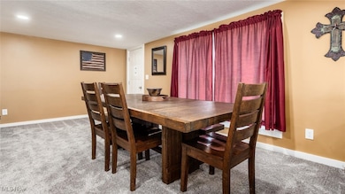 Dining area featuring light colored carpet, a textured ceiling, and recessed lighting