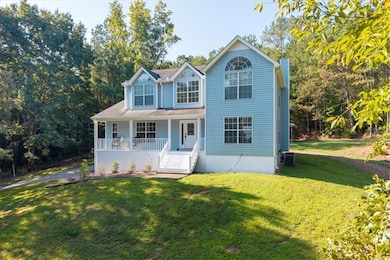 View of front of home featuring covered porch, a front lawn, and a chimney
