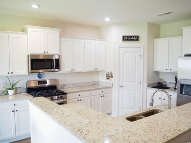 Kitchen with light stone countertops, sink, white 