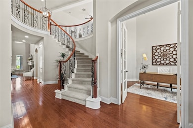 Elegant, curved wrought iron staircase is the focal point of the beautiful entry.