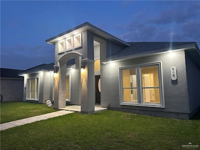Rear view of property with a yard, a patio, and stucco siding