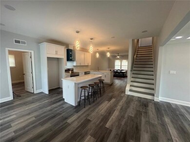 Kitchen with white cabinets, open floor plan, a breakfast bar area, a peninsula, and stainless steel range with electric stove top