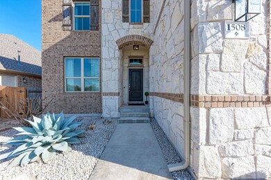 Entrance to property featuring stone siding, bric