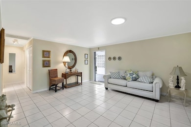 Living room with light tile patterned floors and ornamental molding