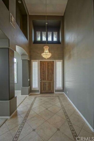 Formal entry with custom tile flooring & chandelie