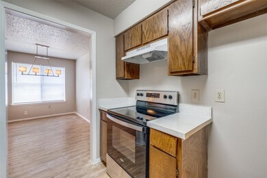 Kitchen featuring a textured ceiling, light hardwo