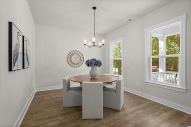 Dining space featuring wood finished floors and a chandelier