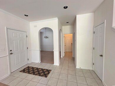 Foyer entrance featuring arched walkways, light ti