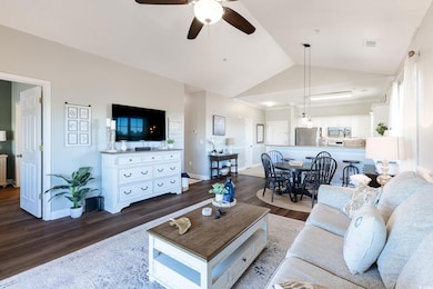 Living room featuring ceiling fan, dark hardwood /