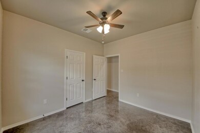 Unfurnished bedroom featuring ceiling fan and finished concrete flooring