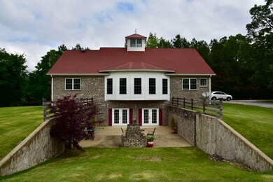 Rear view of property featuring french doors, a patio area, and brick siding