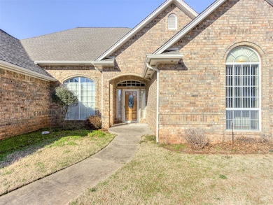 Doorway to property featuring a lawn, brick siding