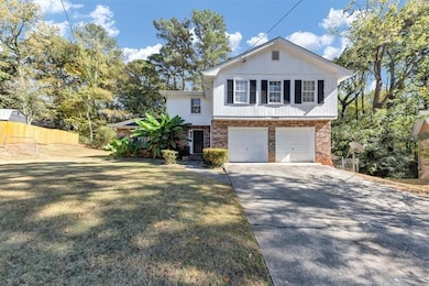 View of front facade with brick siding, concrete driveway, and an attached garage